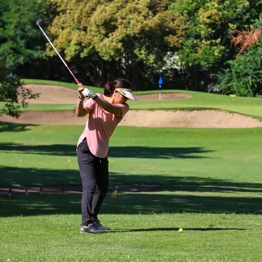Female golfer hitting fairway shot at William Land Golf Course in Sacramento