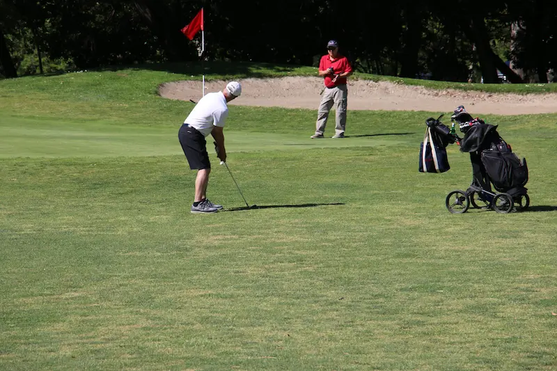Golfer chipping toward green at William Land Golf Course in Sacramento