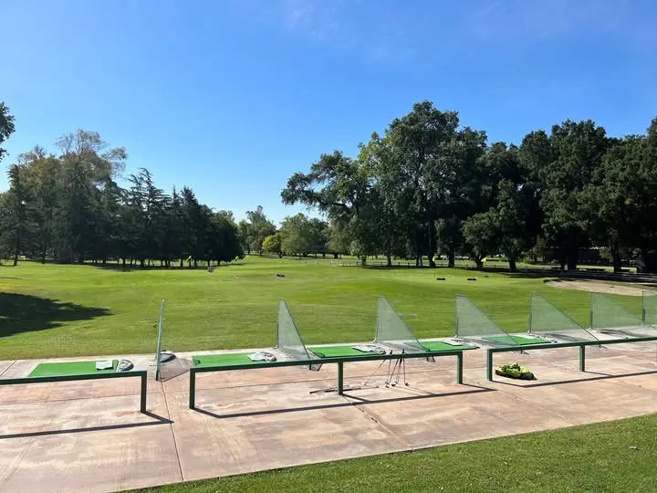 William Land Golf Course practice range with hitting bays and fairway view
